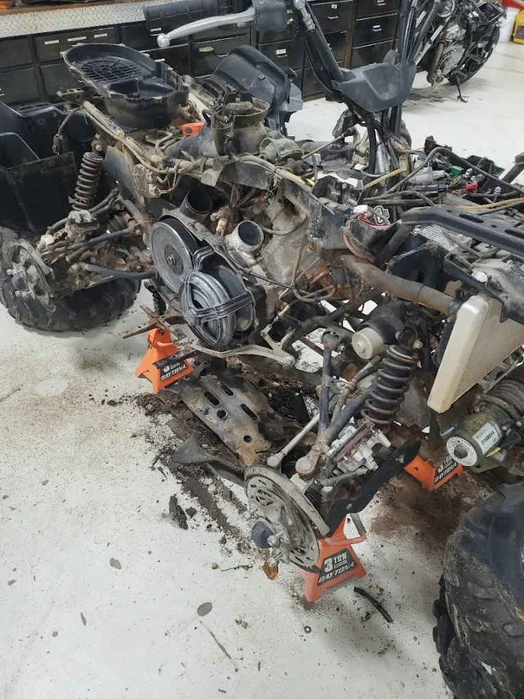 ATV on jack stands mid-repair in the shop